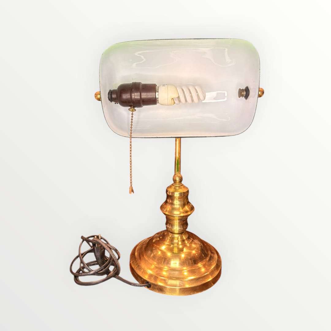  Su pantalla curva en tono verde intenso, combinada con una base metálica dorada de perfil torneado, crea una pieza con alma vintage, ideal para despachos, bibliotecas, estudios, recepciones o rincones de lectura. La silueta recuerda al universo de las lámparas de banquero, muy apreciadas en decoración por su elegancia sobria y
