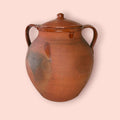 Esta Orza antigua de barro cocido es una pieza de fuerte carácter tradicional, pensada originalmente para conservar alimentos y mantener su contenido protegido gracias a su tapa y a la naturaleza del barro.
