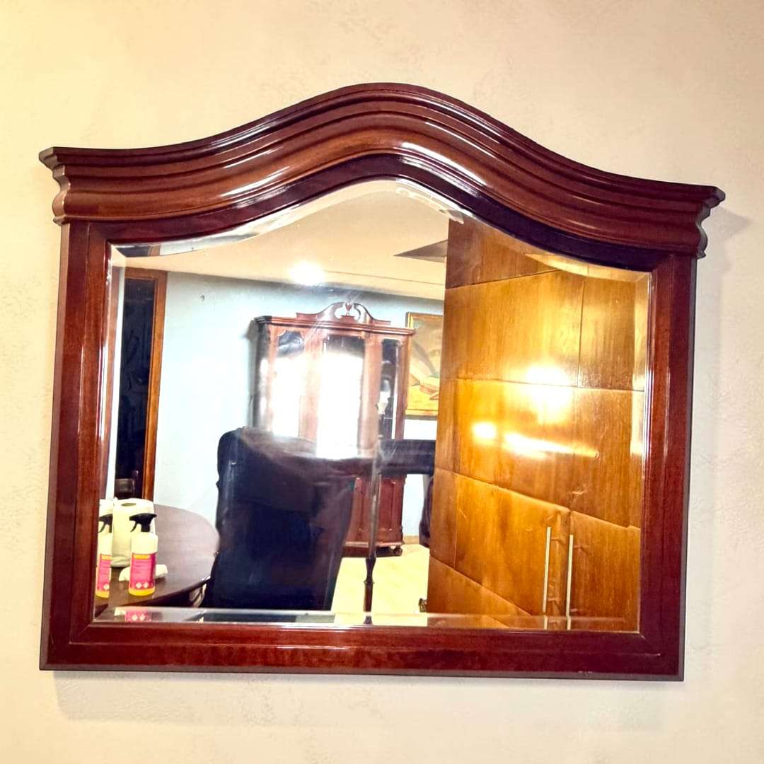 El marco en caoba presenta un tono cálido, profundo y uniforme, con acabado pulido que resalta la veta natural de la madera.