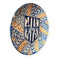 Esa combinación de escudo central y ritmo geométrico le da un aire de inspiración histórica, decorativa y muy especial, perfecto para interiores con gusto por la cerámica con personalidad.
