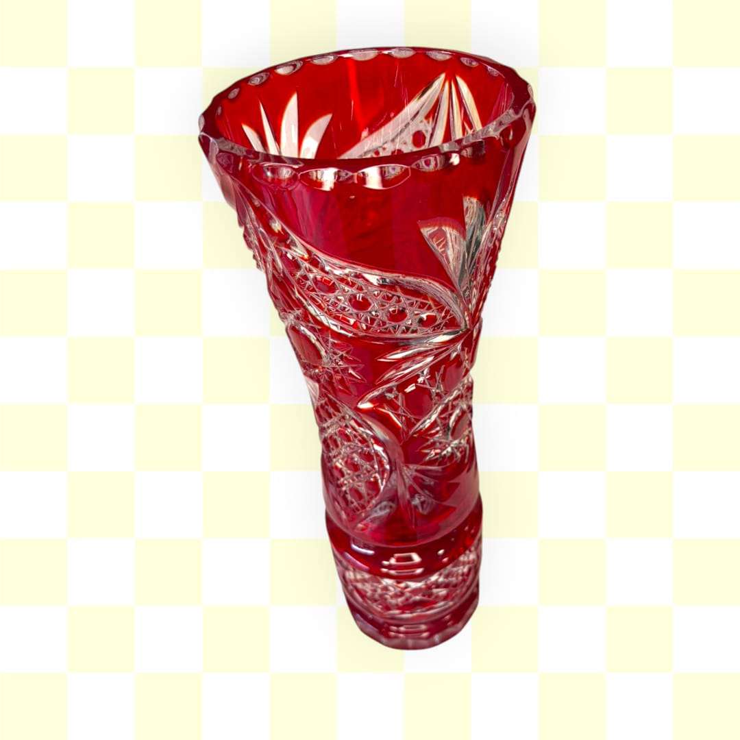 Este Florero está realizado en cristal rojo rubí con relieves tallados, combinando transparencia, color y un trabajo ornamental que enriquece toda la superficie. 