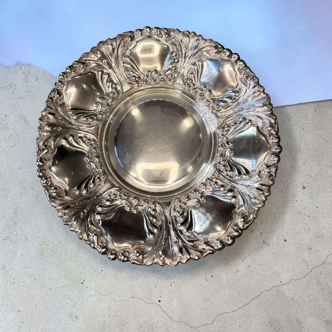 Esta Panera antigua de metal plateado es una pieza elegante, decorativa y funcional, creada originalmente para presentar pan, bollería, dulces o pequeños aperitivos en la mesa. 