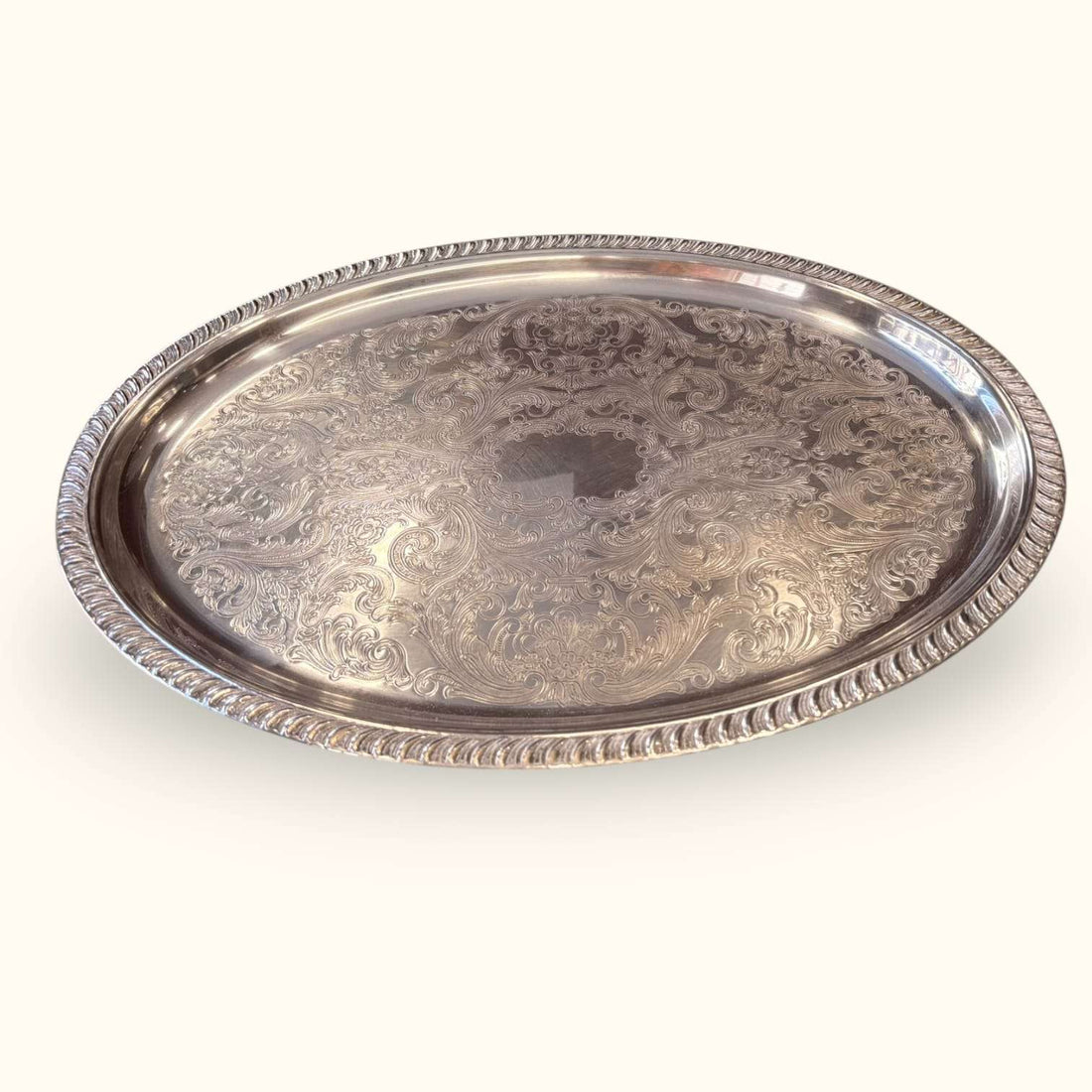 Bandeja antigua de metal plateado con relieves decorativos y borde elevado, pieza vintage para decoración y servicio.