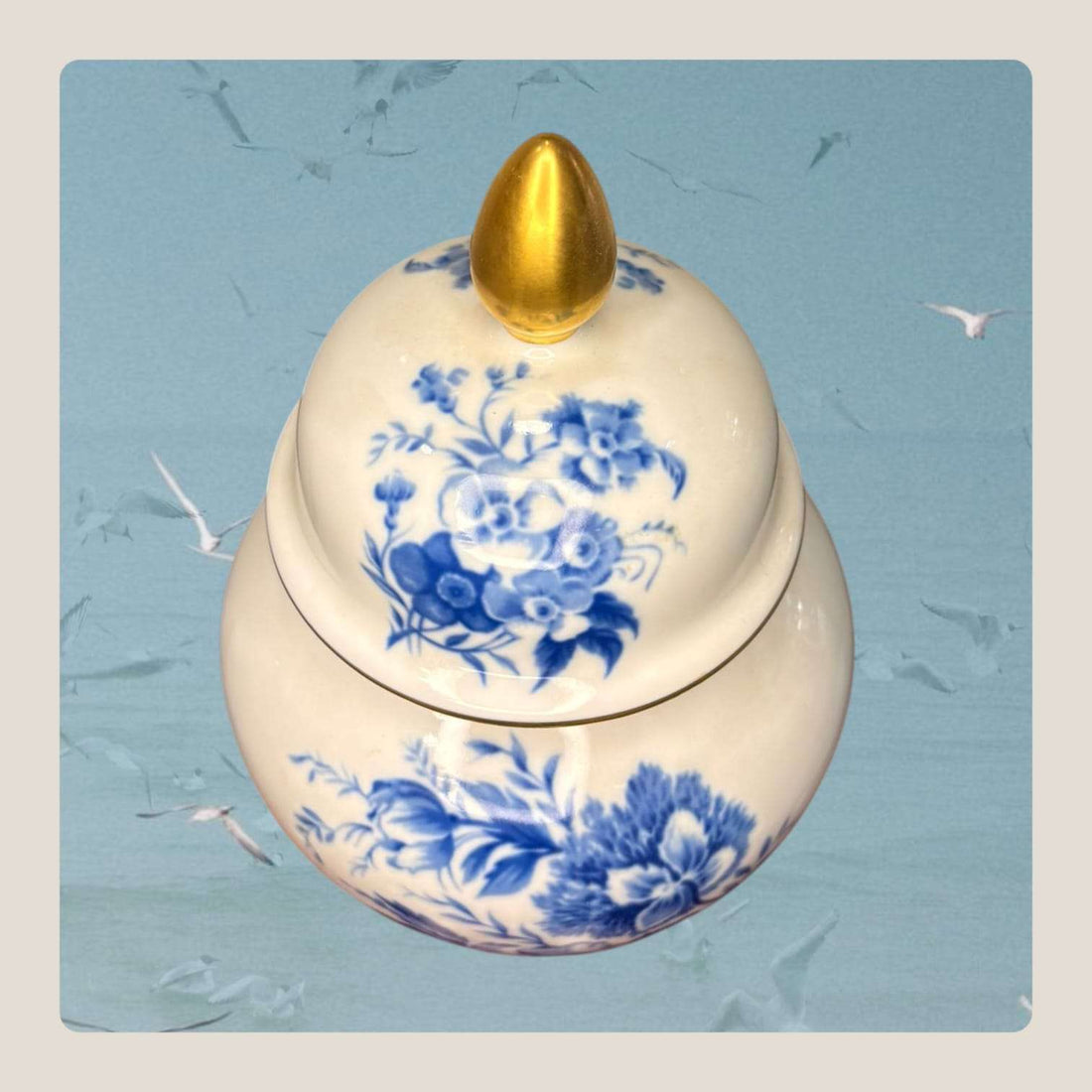 Este Tibor antiguo de porcelana destaca por su elegancia clásica, su decoración floral en azul intenso y sus delicados detalles dorados.