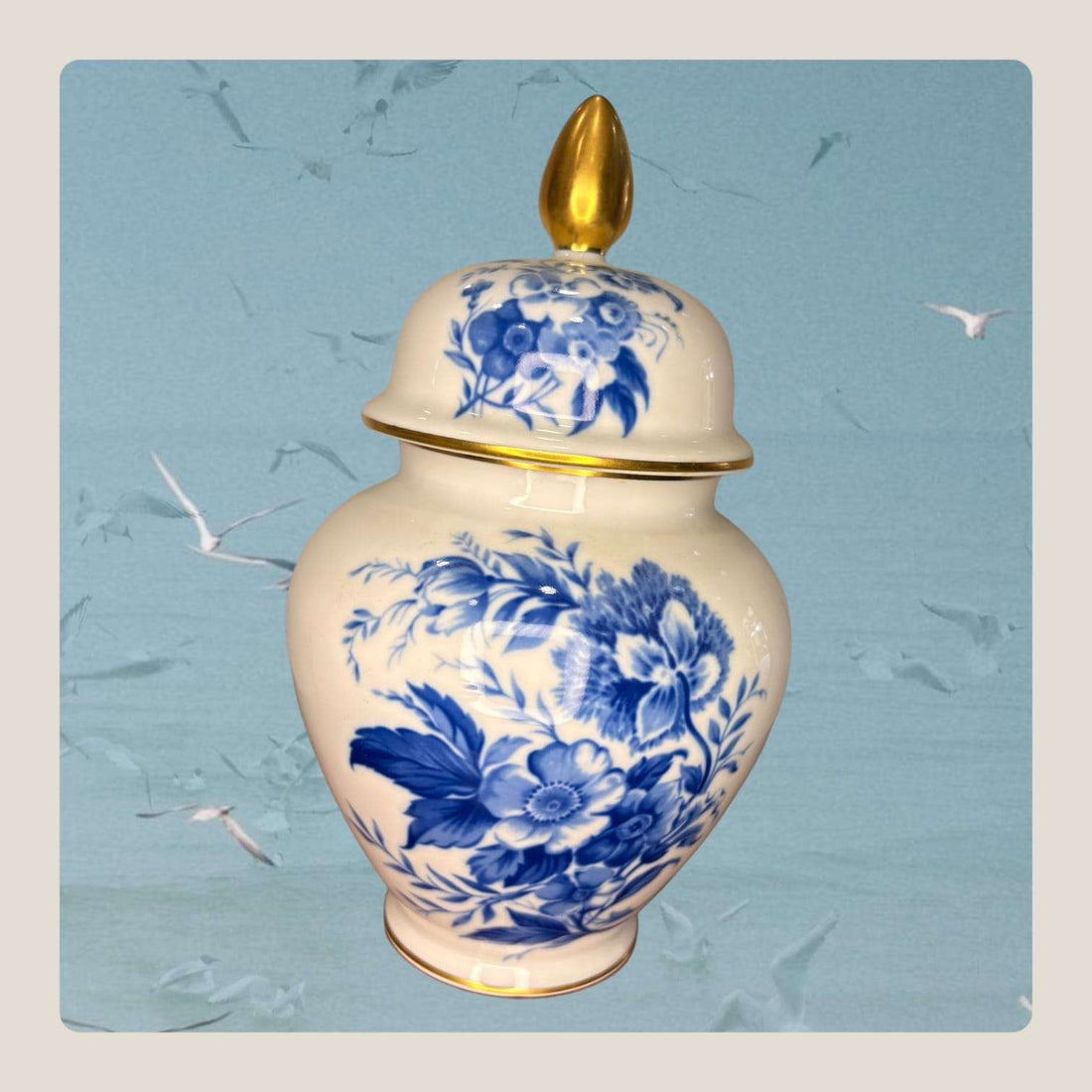 Este Tibor antiguo de porcelana destaca por su elegancia clásica, su decoración floral en azul intenso y sus delicados detalles dorados.