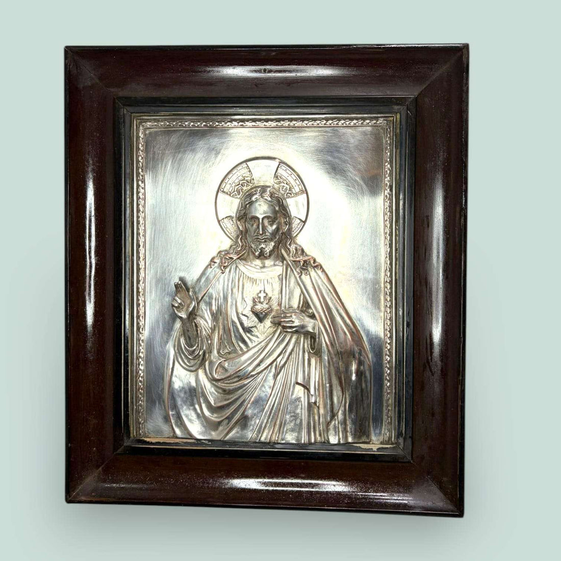 Este Relieve de Cristo Rey combina brillo, solemnidad y profundidad. La placa plateada aporta luz y presencia, mientras el marco de madera crea contraste y equilibrio. 