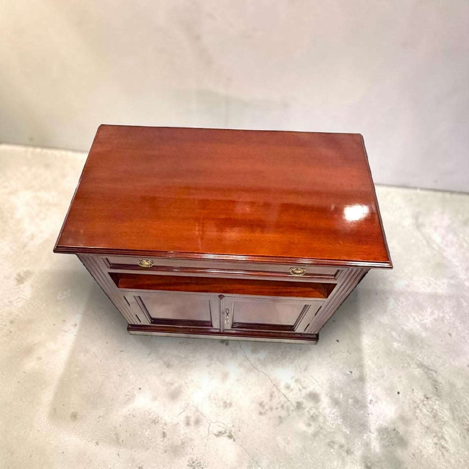 Su función principal es servir como soporte para televisión, equipo multimedia, decoración o piezas auxiliares, pero su valor real está en la calidez de la madera, el brillo del acabado y la capacidad de convertir una zona práctica en un rincón elegante.
