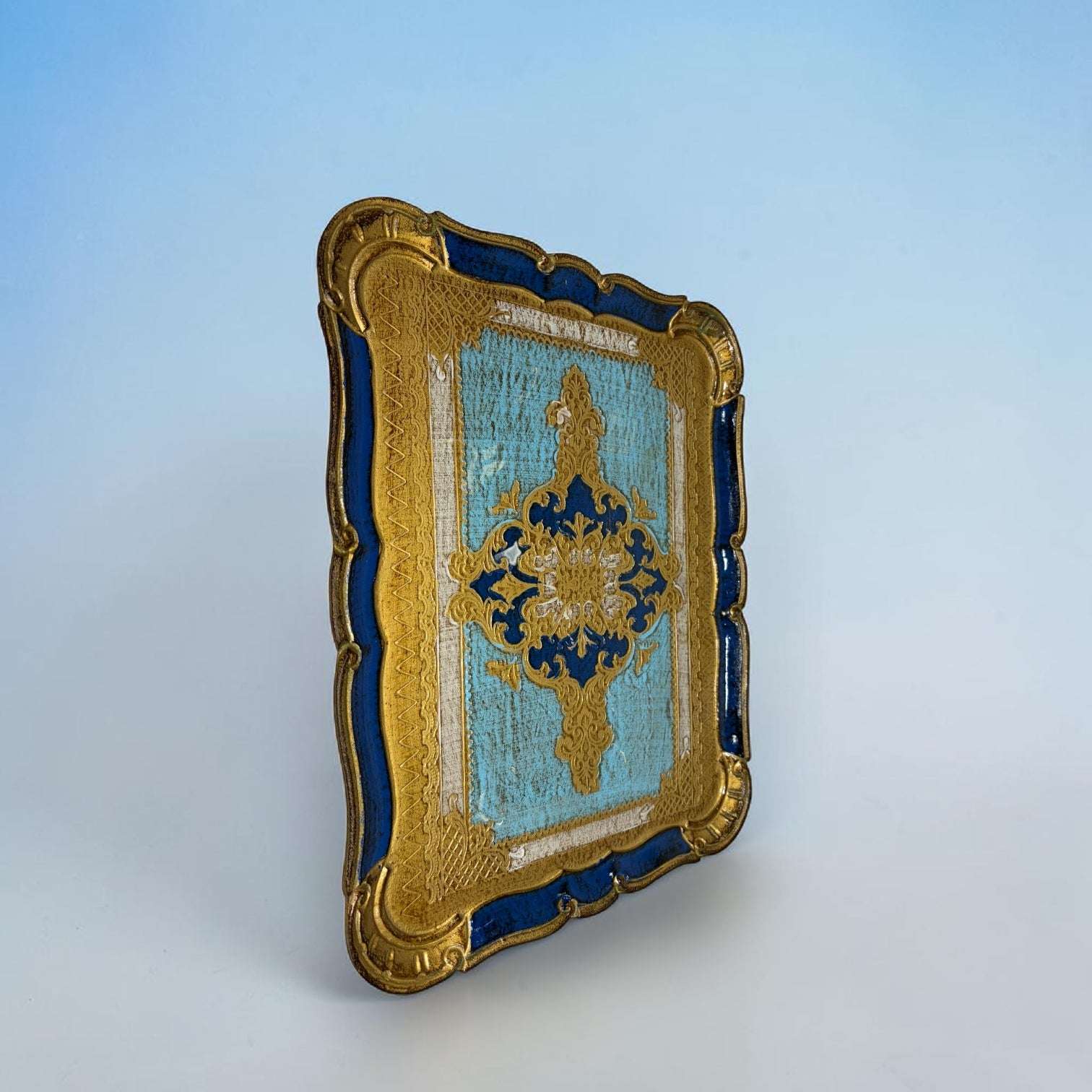  Está pintada a mano en tonos azul celeste, azul intenso y dorado, con una composición central ornamental que recuerda a los motivos clásicos de la decoración florentina. 