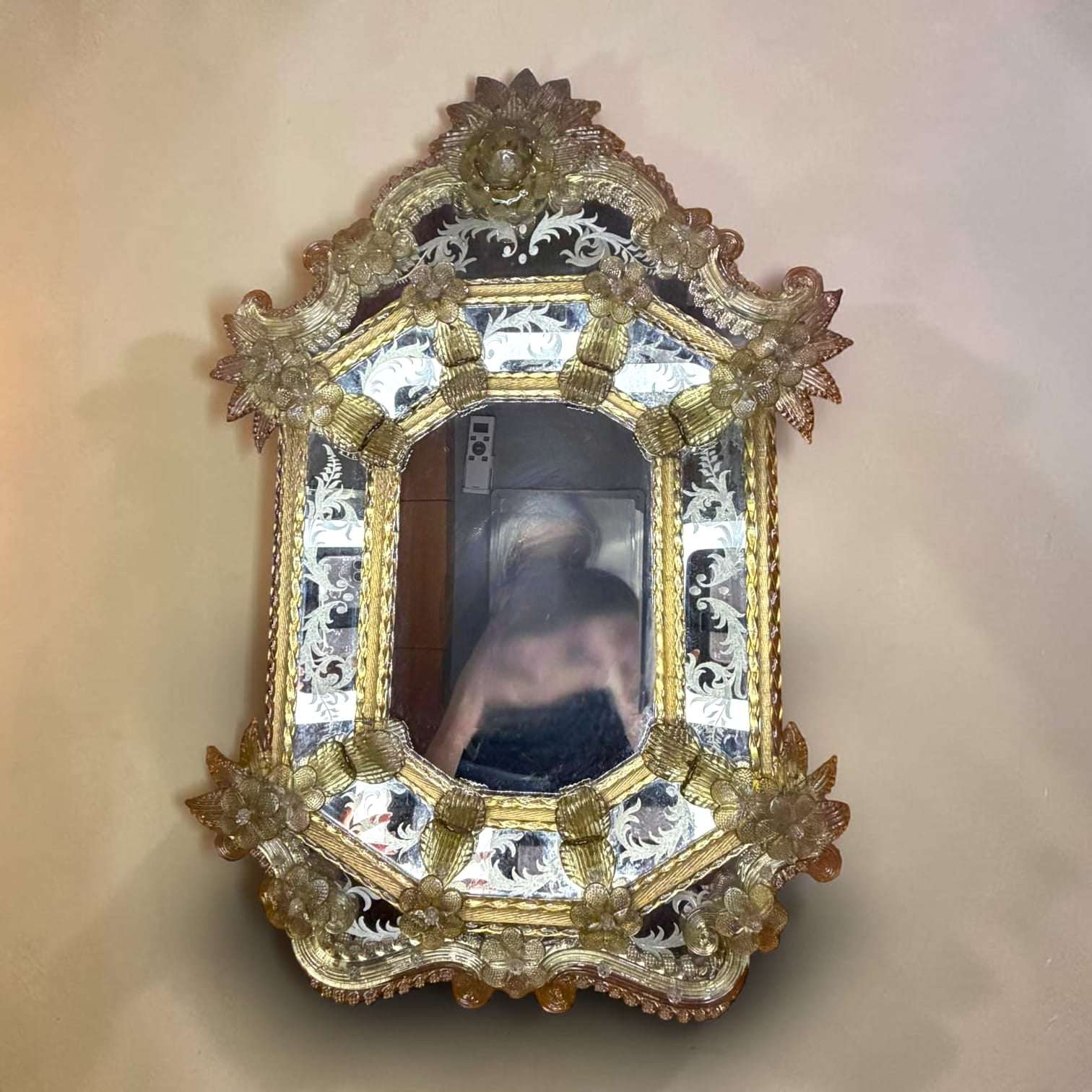 En las imágenes se aprecian flores de cristal distribuidas alrededor del marco, grabados vegetales sobre las placas laterales, estructura de varias capas y un diseño muy ornamental que recuerda a los interiores venecianos más elegantes. 