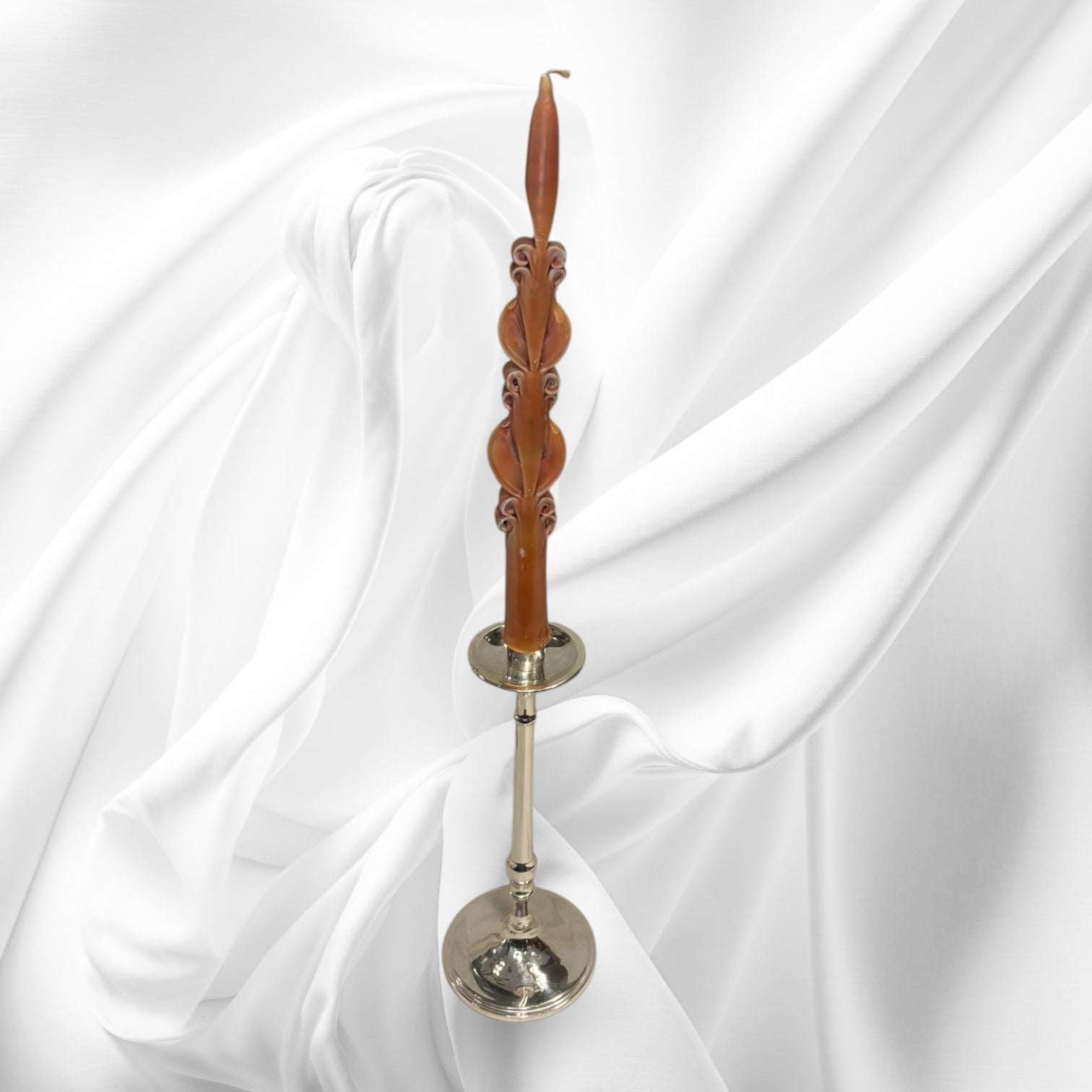 Se presentan como pareja, cada uno con una vela alta de tono marrón cobrizo, trabajada con relieves ornamentales que aportan un toque artesanal y distinguido. 