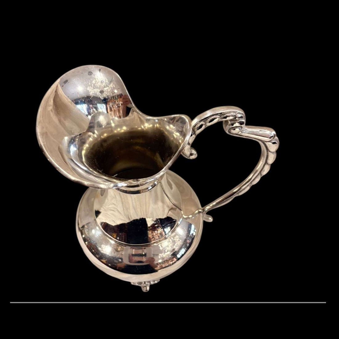 Esta Jarra de metal plateado destaca por su silueta estilizada y por la elegancia de sus líneas, pensadas para realzar cualquier ambiente con un toque distinguido. 