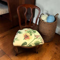 Su diseño combina una estructura de madera cálida, respaldo calado de líneas curvas y tapizado floral en tonos suaves, creando un conjunto decorativo con presencia, funcionalidad y encanto.


