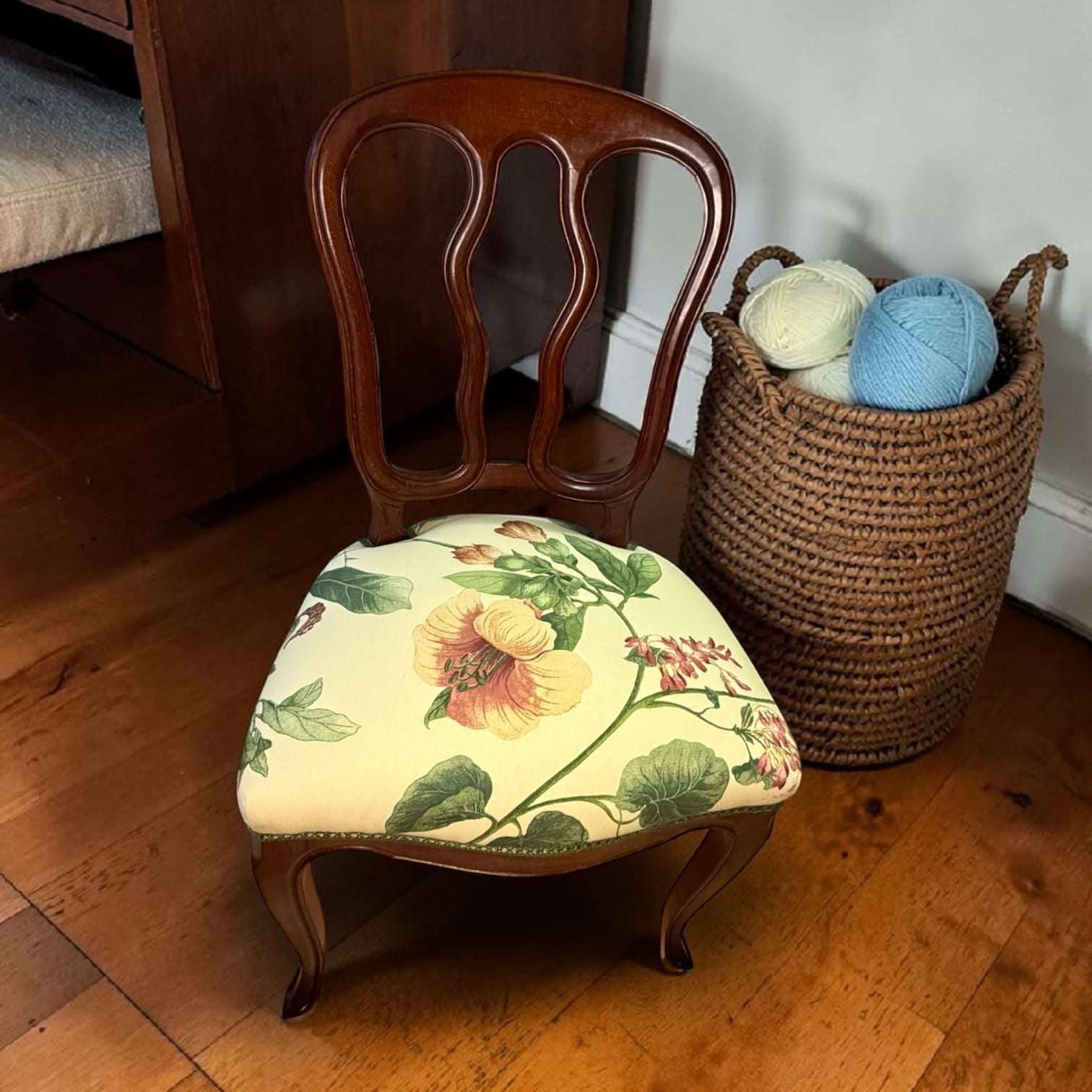Su diseño combina una estructura de madera cálida, respaldo calado de líneas curvas y tapizado floral en tonos suaves, creando un conjunto decorativo con presencia, funcionalidad y encanto.

