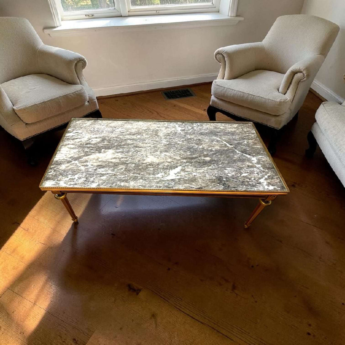 Esta Mesa baja de salón combina tres elementos que siempre elevan una estancia: caoba, mármol oscuro y detalles metálicos dorados. 
