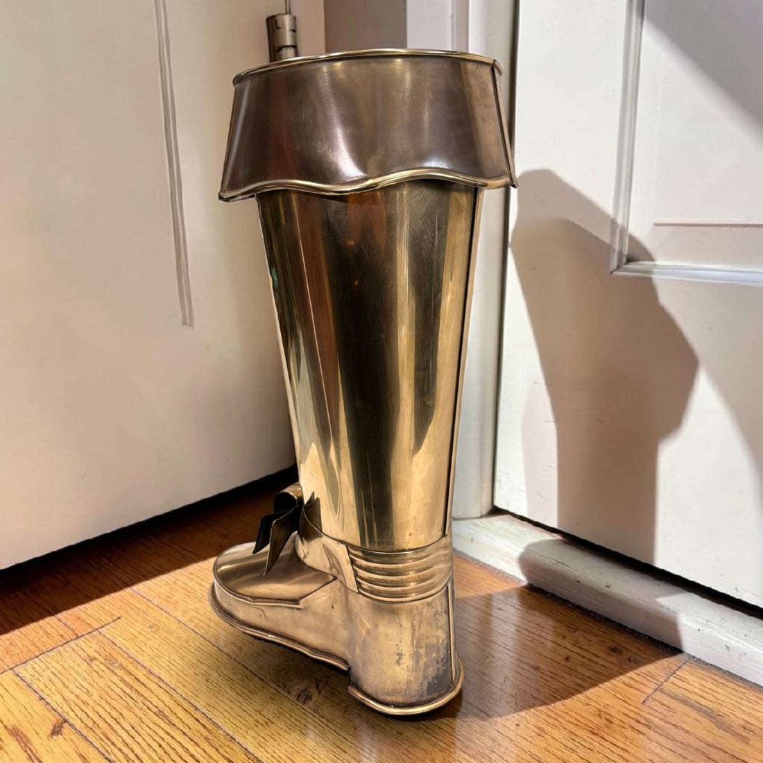 En las imágenes se aprecia un diseño muy singular con forma de bota alta, trabajado en metal plateado con acabado envejecido. 