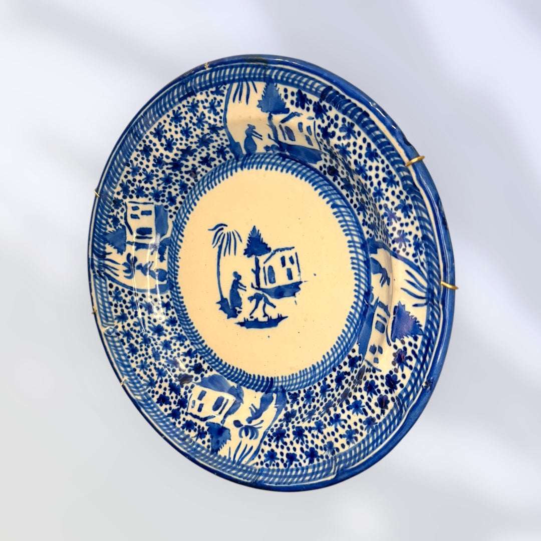 En la parte trasera conserva la marca F.M. en azul, además de un sistema metálico con muelles y alambres preparado para colgarlo directamente en la pared.