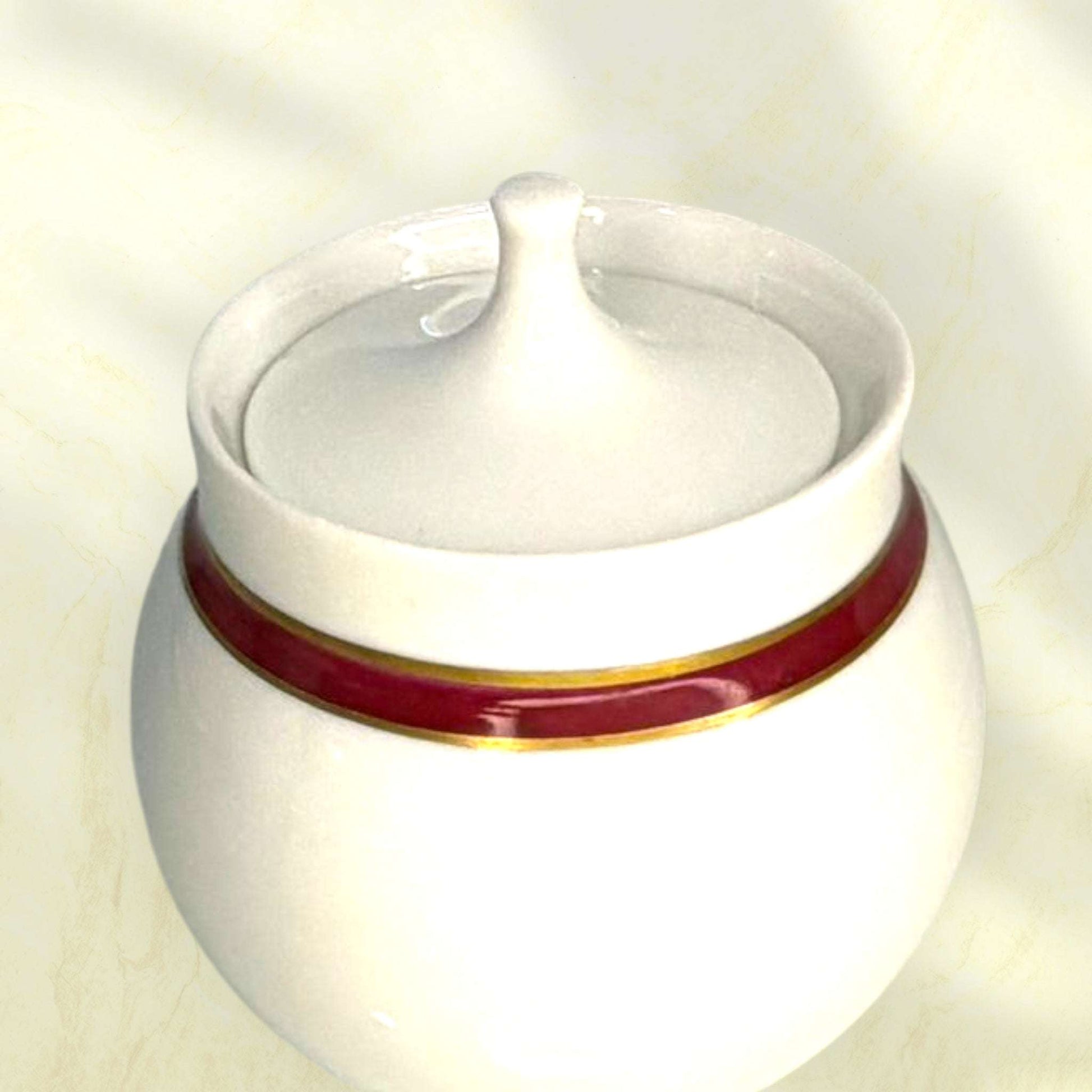 Jarra de porcelana española con filo dorado y borde granate