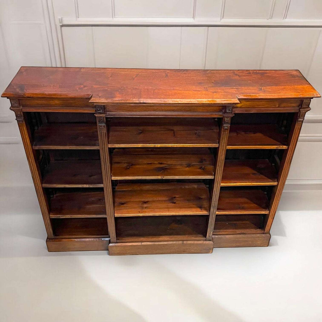 La Libería baja destaca porque no solo sirve para ordenar: también viste una pared completa con presencia, historia y calidez.