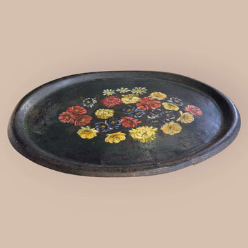 Esta Bandeja antigua de tole, realizada en metal pintado, es una pieza decorativa con gran personalidad visual.