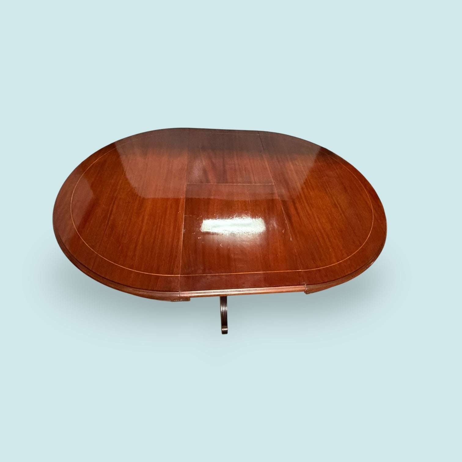 Vista lateral de mesa de caoba con pie torneado y taracea