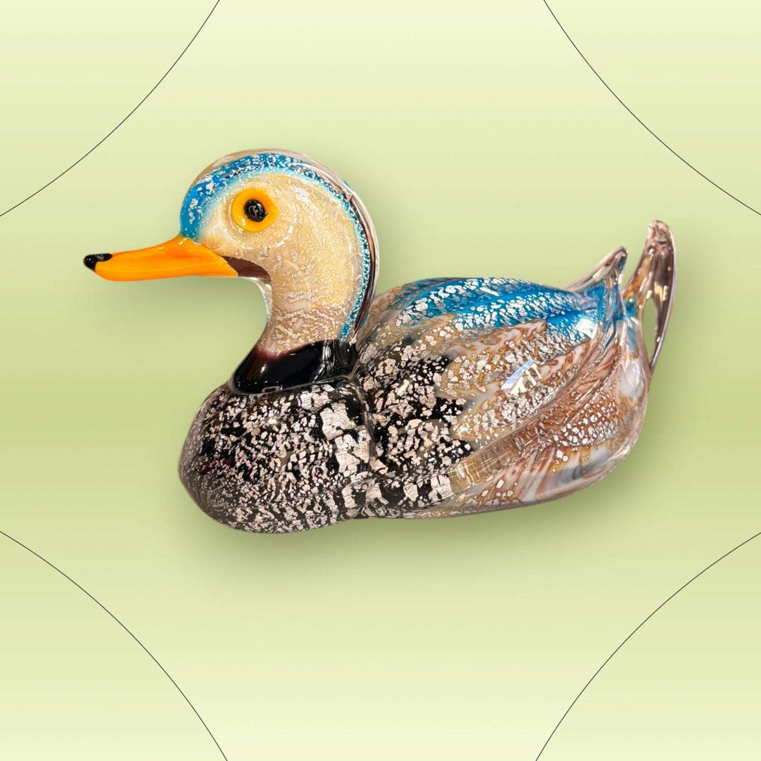 El Pato destaca por su combinación de color, brillo y forma. La pieza transmite movimiento, ligereza y una presencia muy especial gracias a su cuerpo alargado, su cola levantada y su acabado luminoso. 