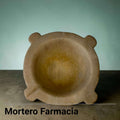 El mortero presenta una forma baja y robusta, con cavidad interior redondeada, borde grueso y cuatro salientes redondeados que actúan como apoyos visuales y detalles de diseño. 