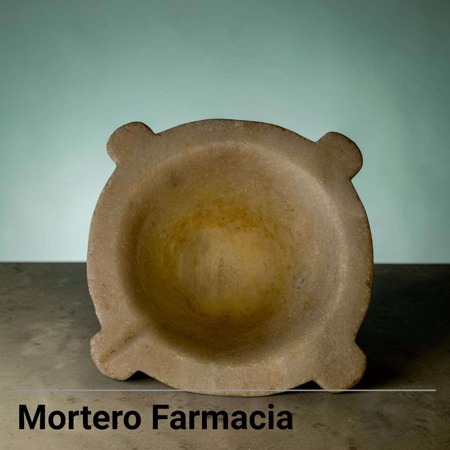 El mortero presenta una forma baja y robusta, con cavidad interior redondeada, borde grueso y cuatro salientes redondeados que actúan como apoyos visuales y detalles de diseño. 