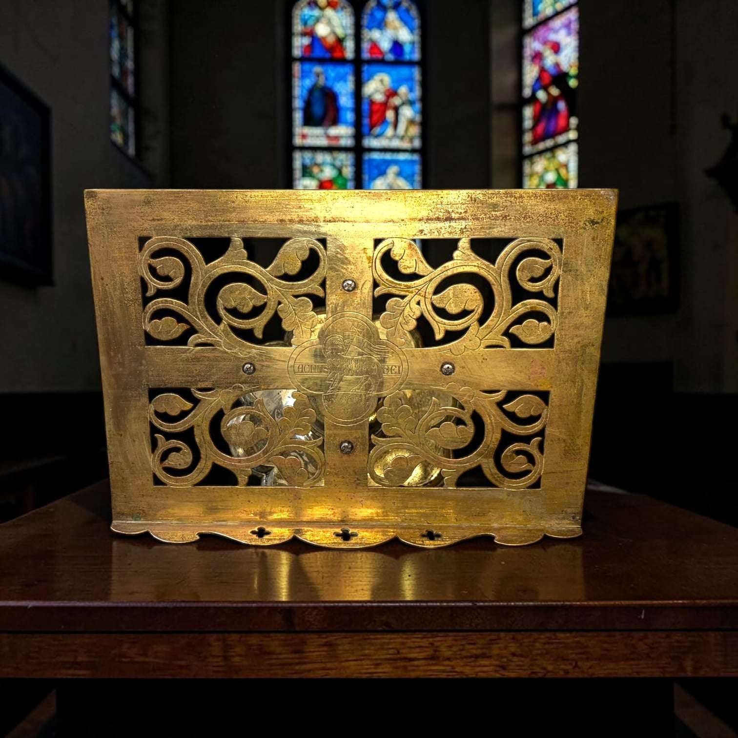 En el centro se aprecia un medallón religioso con figura de cordero y cruz, detalle que refuerza su lectura sacra sin necesidad de atribuir una datación exacta no confirmada.