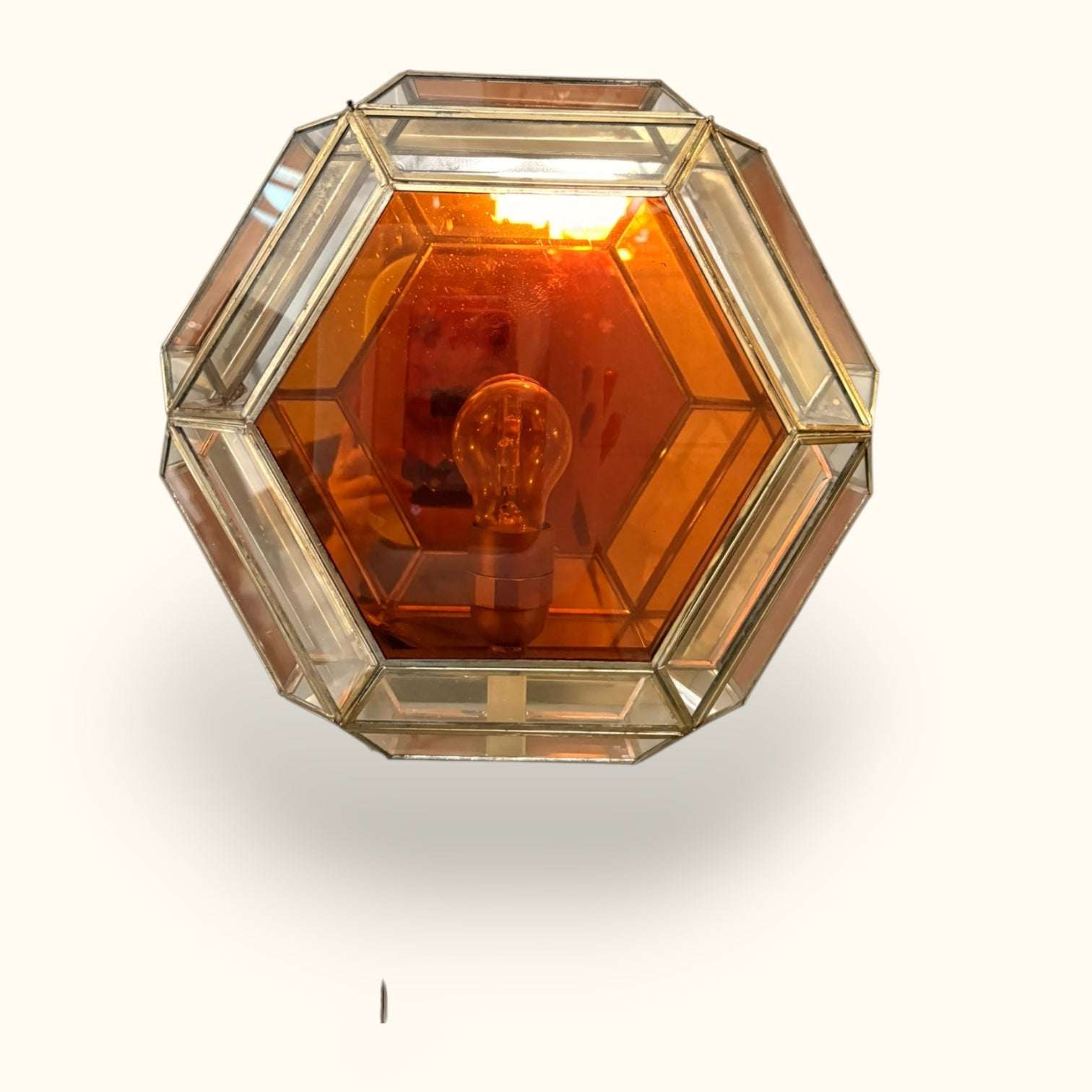 Su forma hexagonal le aporta una presencia muy especial, casi como un pequeño farol arquitectónico pensado para proyectar una luz cálida, íntima y envolvente.