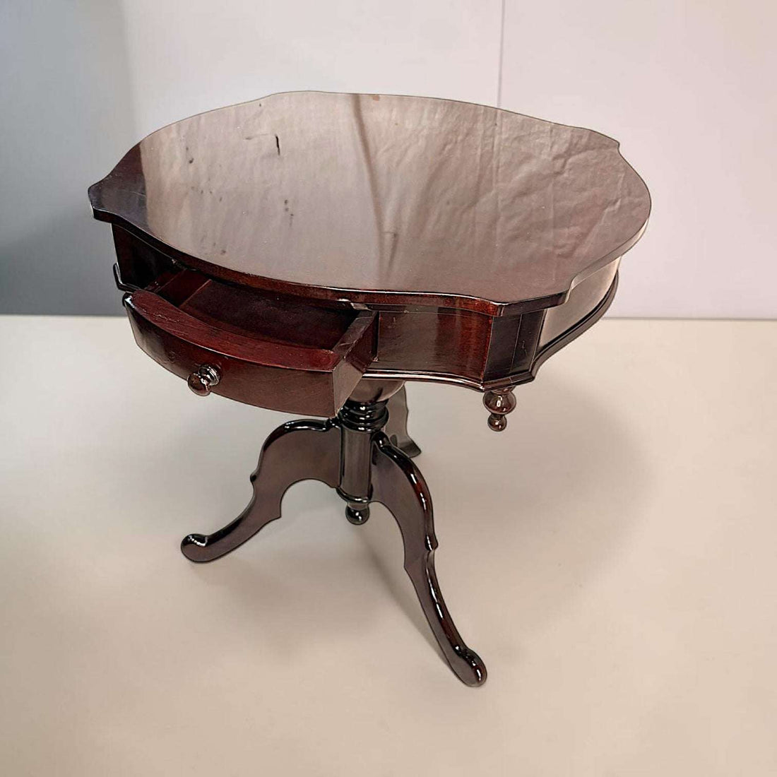 Esta pieza de caoba destaca por su presencia elegante, su brillo profundo y su formato compacto, pensado para aportar utilidad sin ocupar demasiado espacio. 