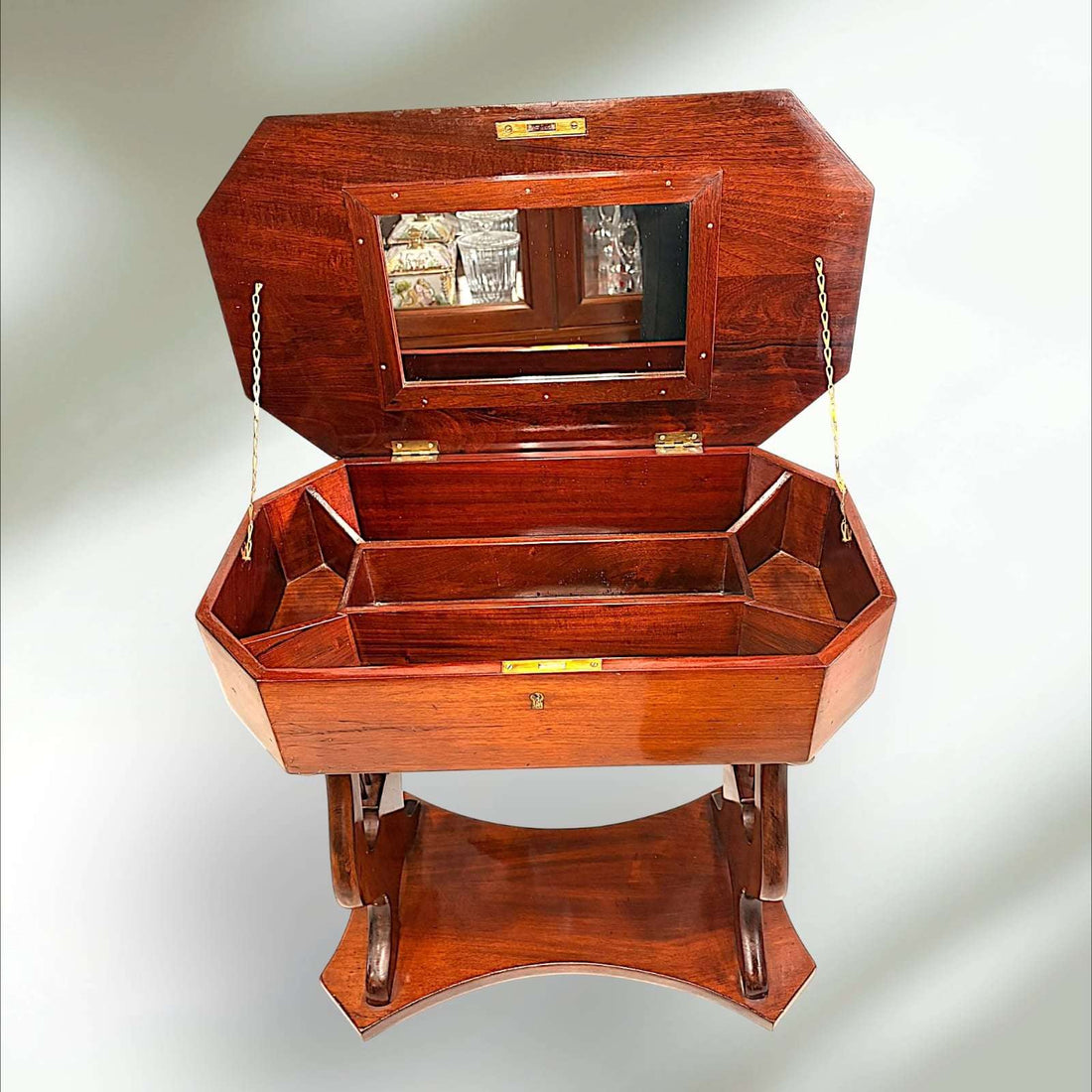  La pieza presenta una tapa abatible de líneas facetadas, acabado brillante y un interior compartimentado que permite apreciar su función original. 