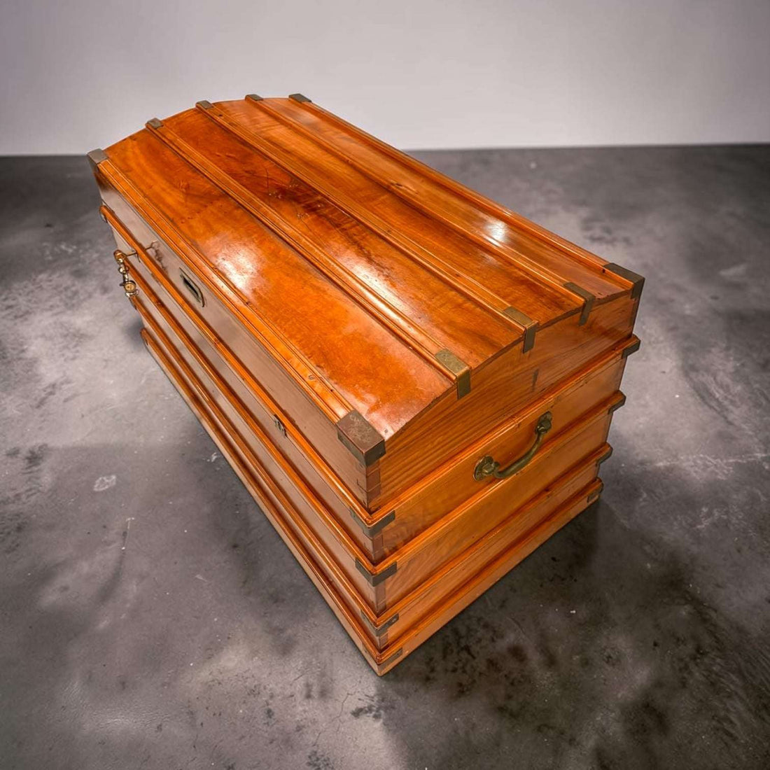 Este Arcón de campaña del siglo XIX en madera de cedro es una pieza con una presencia extraordinaria, pensada originalmente para guardar, proteger y transportar objetos personales, ropa, documentos, textiles o pertenencias de valor durante desplazamientos. 