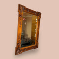  El Espejo cuenta con un marco trabajado en madera, decorado con motivos florales tallados, formas vegetales, roleos ornamentales y detalles en las esquinas que recuerdan a abanicos o conchas decorativas. 