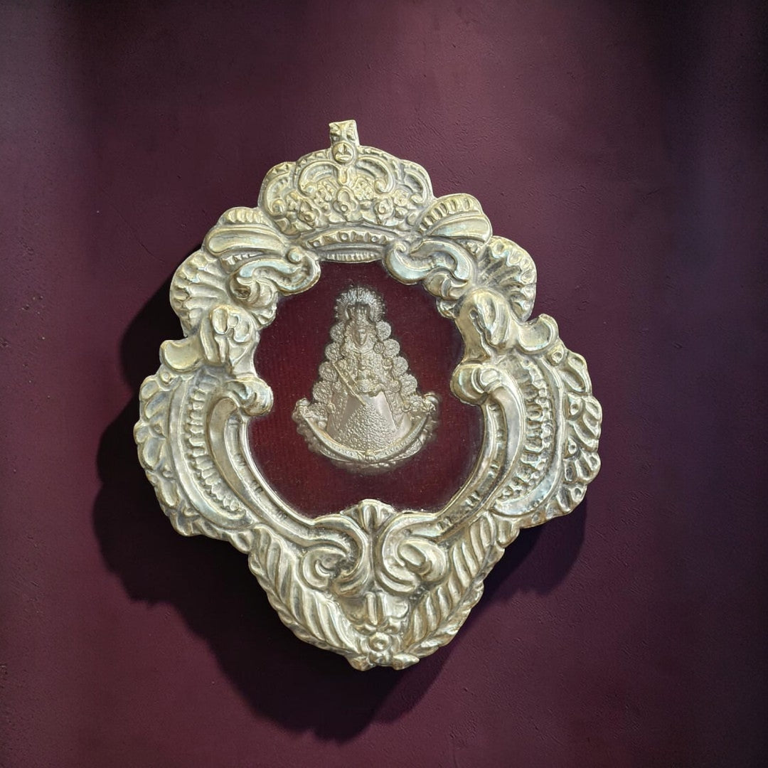 El metal plateado muestra una pátina suave, con matices envejecidos en los relieves que ayudan a destacar la profundidad del trabajo ornamental.