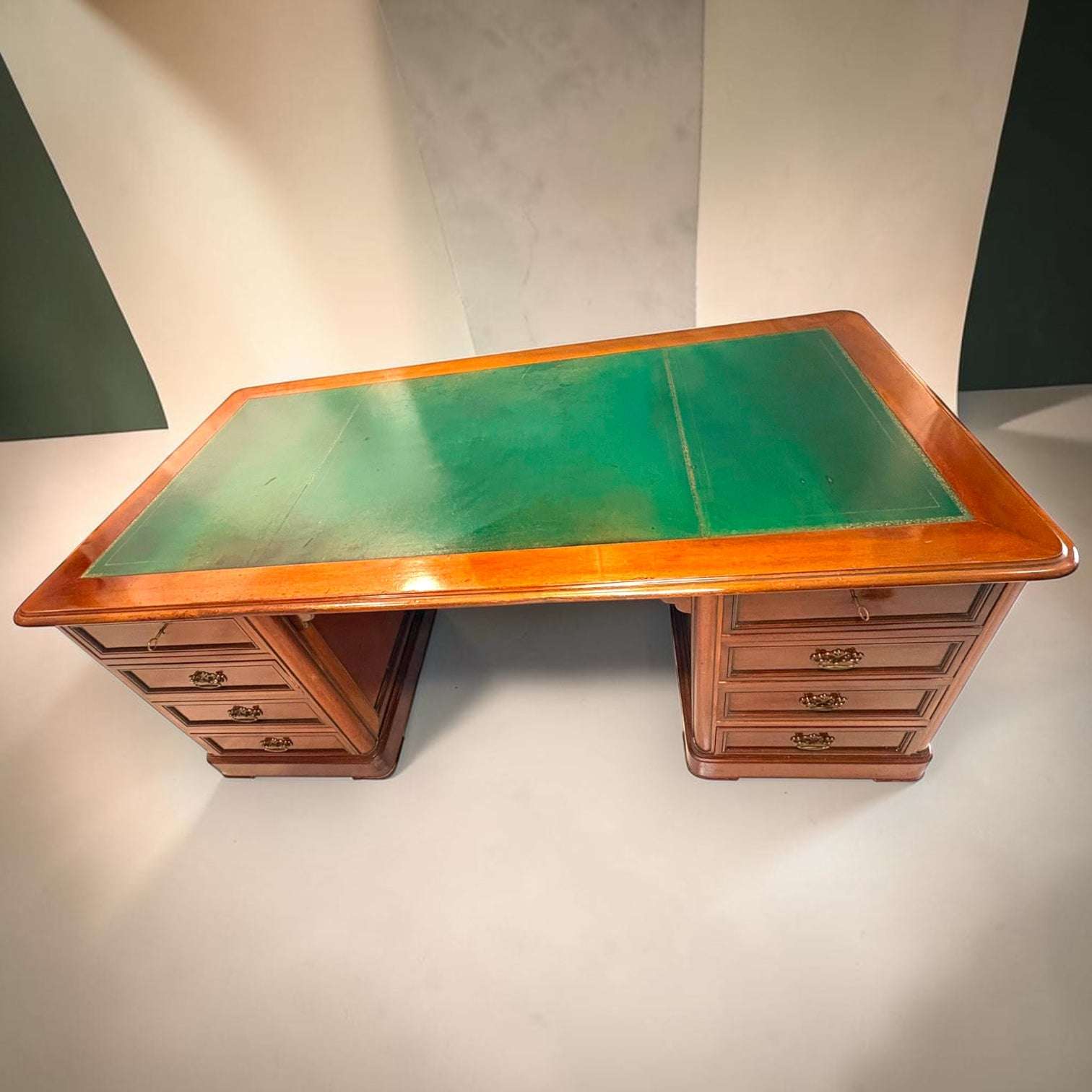 En las fotografías se aprecia una estructura de doble pedestal, con hueco central para las piernas y cajoneras laterales. La tapa verde presenta señales propias del uso, lo que refuerza su autenticidad y su carácter de pieza vivida.