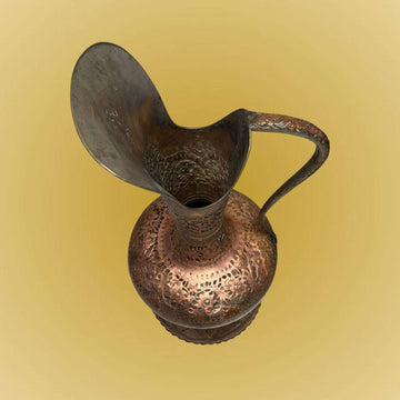Gran jarra de cobre antigua de gran presencia decorativa, realizada en cobre trabajado con acabado amartillado, relieves florales y una estética de inspiración musulmana, probablemente turca.