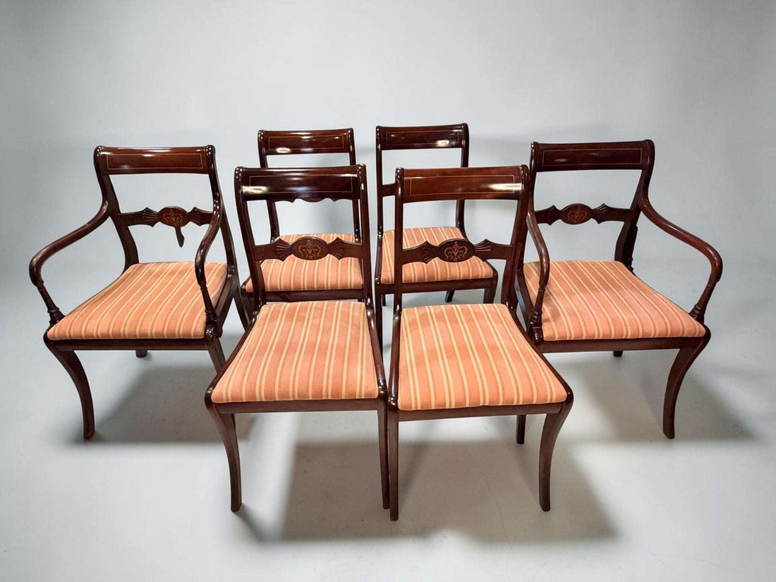 Juego de seis sillas compuesto por dos sillones con brazos y cuatro sillas auxiliares, realizado en caoba y con asientos tapizados. 