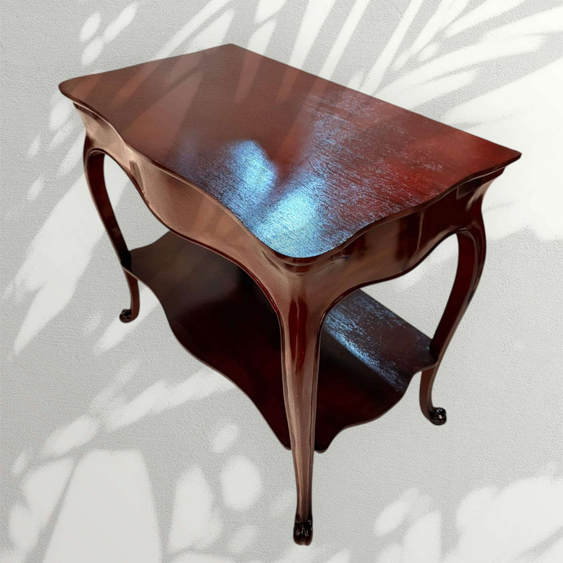 Esta mesa auxiliar de caoba destaca por su diseño elegante, sus líneas curvas y su acabado brillante, ideal para aportar un toque clásico y distinguido a cualquier estancia.