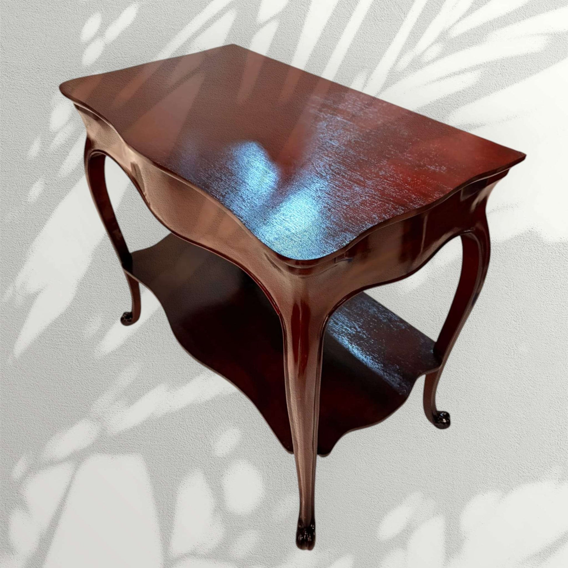 Esta mesa auxiliar de caoba destaca por su diseño elegante, sus líneas curvas y su acabado brillante, ideal para aportar un toque clásico y distinguido a cualquier estancia.