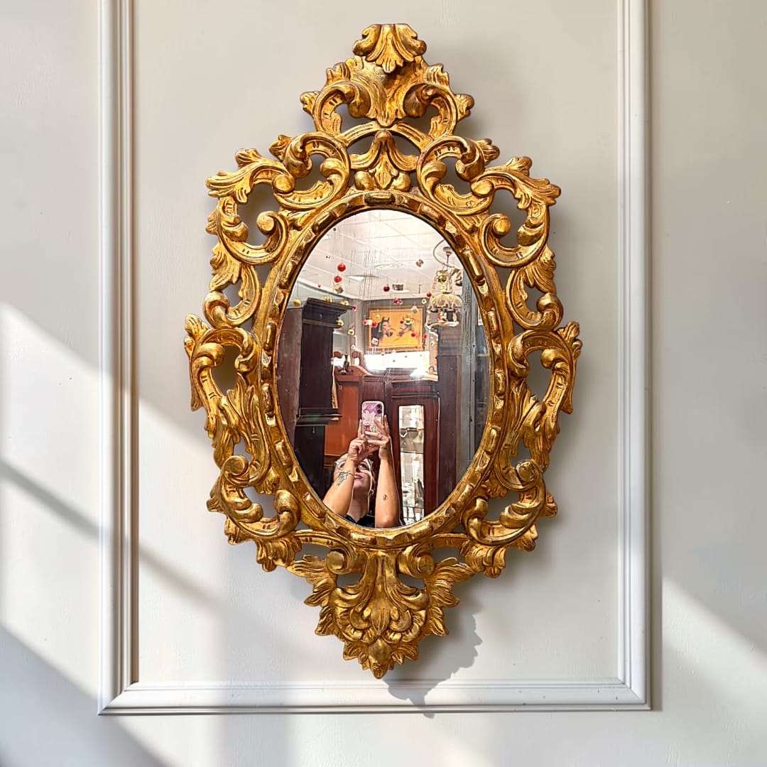 El Espejo conserva una estética de inspiración barroca y rococó, con volumen marcado, talla vegetal y un acabado dorado de aspecto envejecido que aporta riqueza visual. 