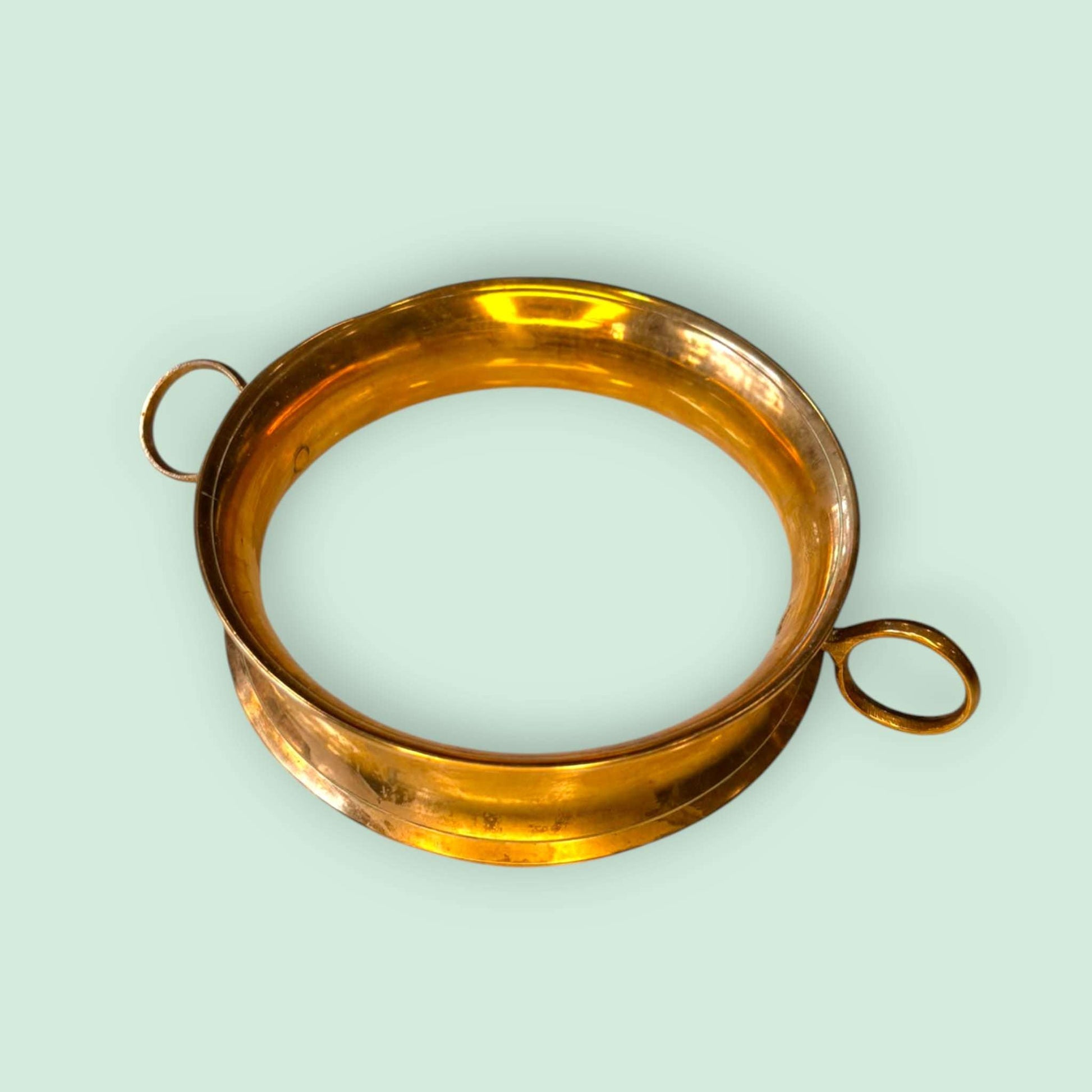 Este Apoya ollas de metal dorado es una pieza funcional y decorativa pensada para proteger mesas, aparadores o superficies delicadas del contacto directo con ollas, cazuelas, fuentes calientes o recipientes de servicio. 