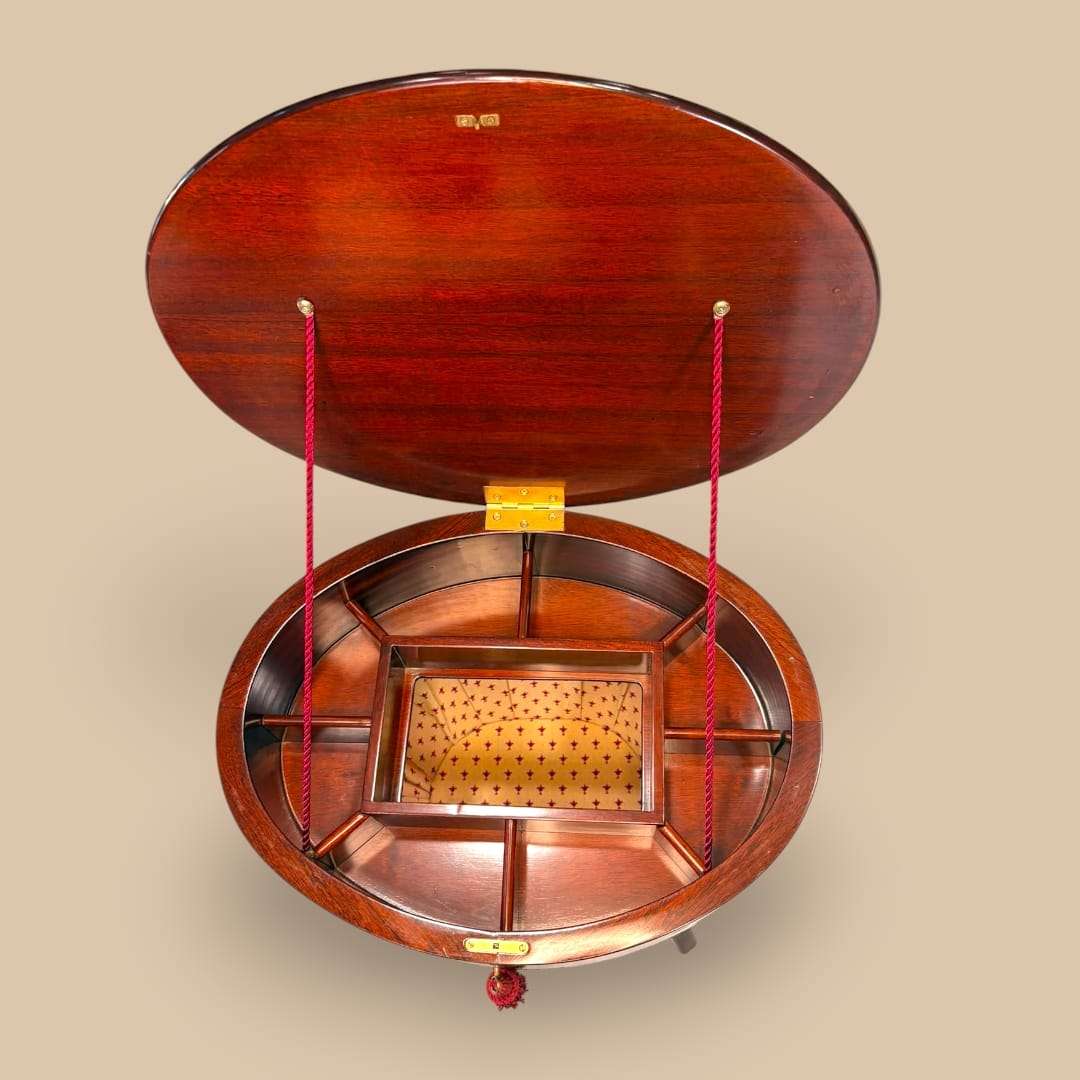 En la parte central incorpora una caja interior independiente, también de madera, con zona acolchada o tapizada, lo que refuerza su función original como mueble de costura.