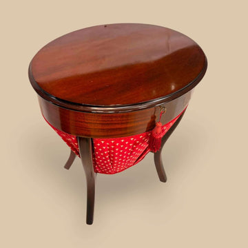 Esta mesa de costura eduardiana de caoba, datada alrededor de 1890, es una pieza antigua de gran encanto, pensada originalmente para guardar útiles de costura, hilos, agujas, dedales, cintas y pequeños accesorios textiles.