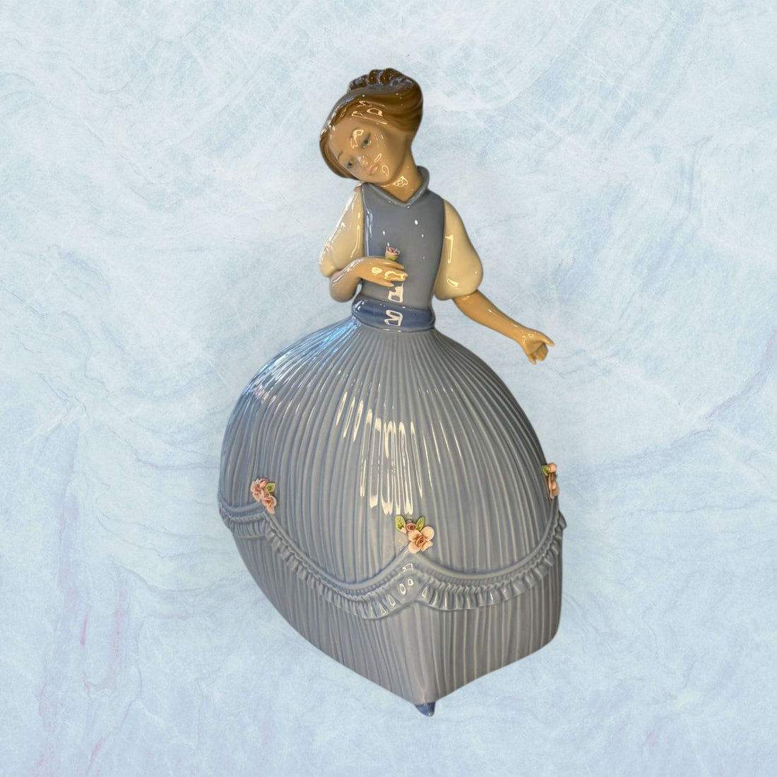 Esta Porcelana Lladró representa una delicada niña con vestido azul, una pieza decorativa pensada para quienes valoran la elegancia de la porcelana española, el coleccionismo y los objetos con sensibilidad artística. 