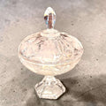 Vista superior de la bombonera de cristal con tapa, mostrando relieves florales y uvas, en acabado transparente y decorativo vintage.