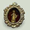 Detalle del relicario Niño Jesús en metal plateado, figura dorada en relieve sobre fondo de terciopelo rojo, SKU: A-138
