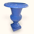 Florero decorativo de cerámica esmaltada en celeste con borde en relieve, base cuadrada y estilo clásico, pieza única en decoración de hogar.