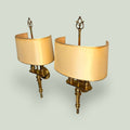 Pareja de apliques de pared en metal dorado con pantallas beige, ideales para iluminar y decorar ambientes con estilo clásico y elegante.