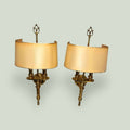 Pareja de apliques dorados de pared con pantalla curva en metal, ideales para decorar salones, entradas o dormitorios con estilo clásico.