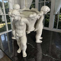 Centro de mesa de porcelana blanca con querubines sosteniendo una cesta, pieza clásica y elegante para decoración de mesas y vitrinas.